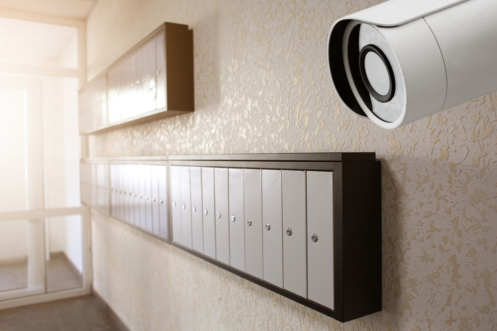 Modern CCTV camera installed for apartment security near mailboxes