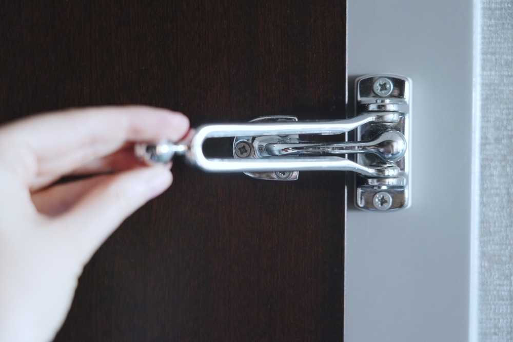 Person's Hand Closing a Door Lock