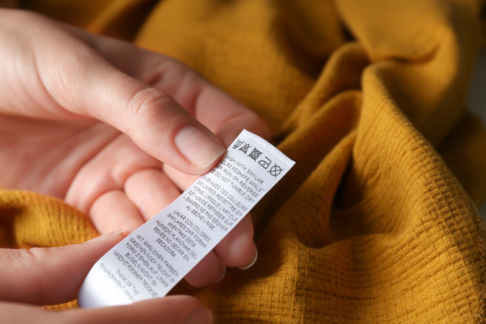 Person Reading Care Instructions on a Clothing Label