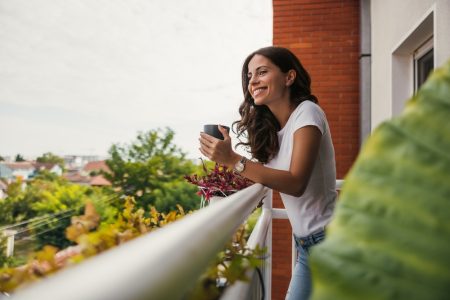 Woman enjoying summer apartment life on a balcony