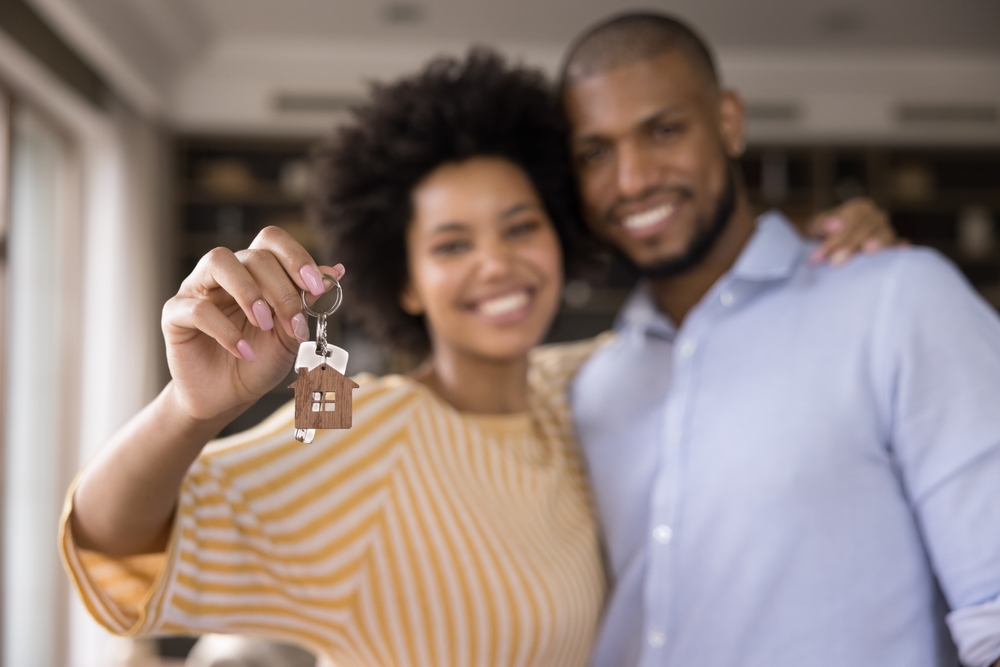 Happy couple with keys to their affordable apartment