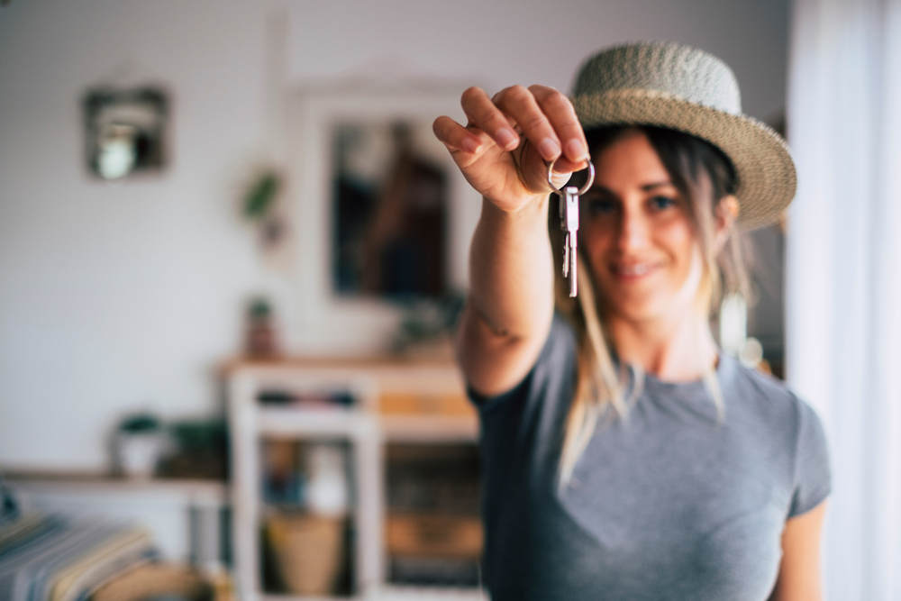 Young woman smiling with keys to an apartment
